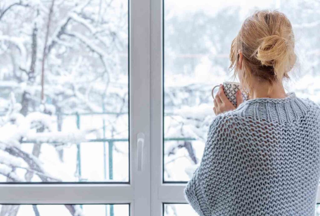 Woman drinking her cup of tea infront of door